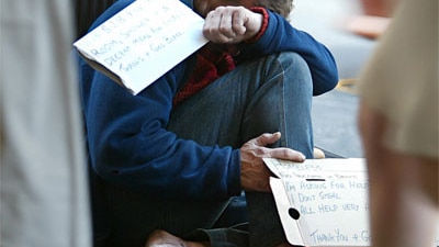 A homeless man begs on the streets of an Australian city