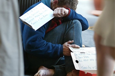 A homeless man begs on the streets of an Australian city