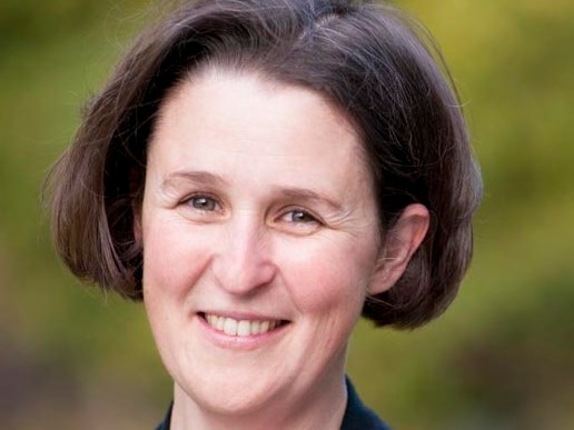 A woman with short brown hair smiling at the camera