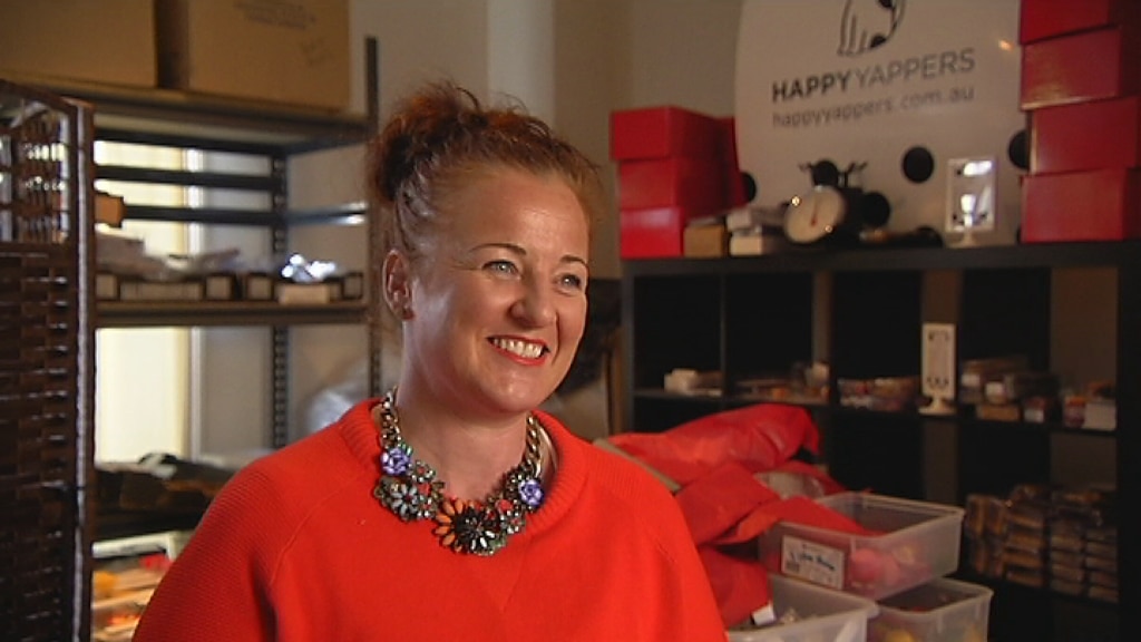 A smiling, middle-aged woman in a brightly-coloured jumper.