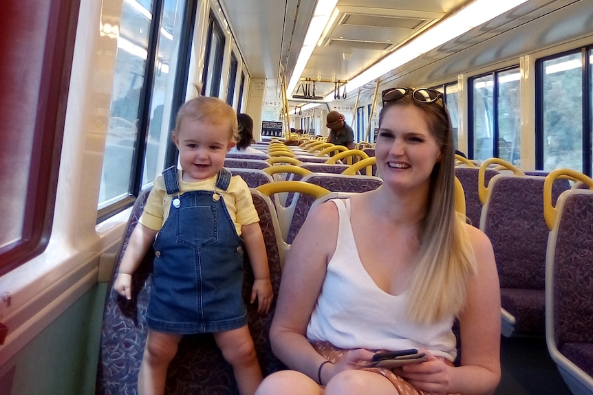 Mother and young toddler sitting on a train.