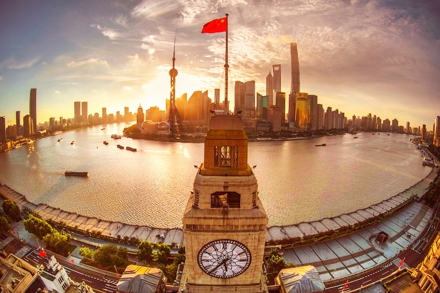A Chinese national flag was standing on top of a historical building in Shanghai in the front of the famous East Bond river view