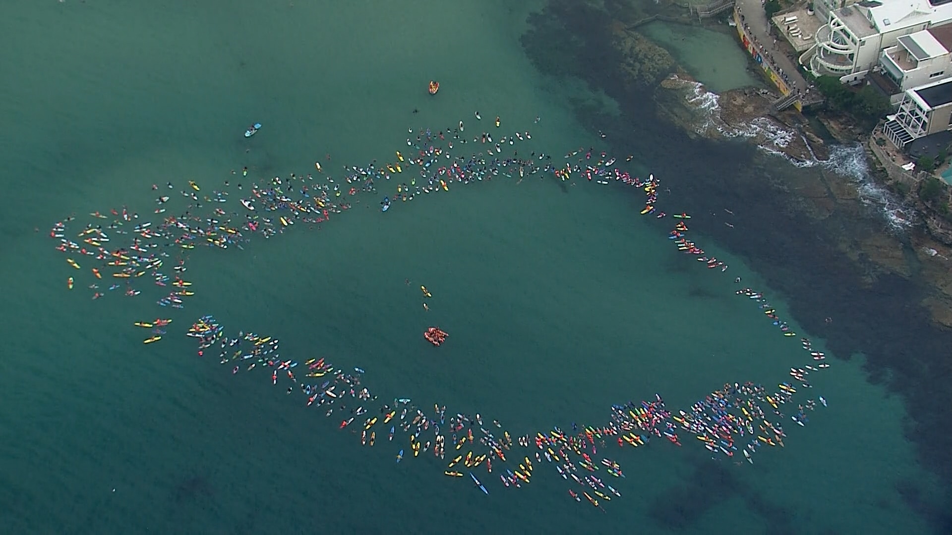 Um círculo se formou no oceano de pessoas praticando paddleboards.