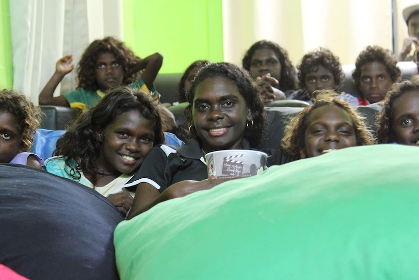 a woman surrounded by children on bean bags