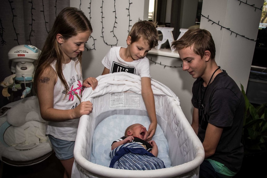 Children around baby's crib