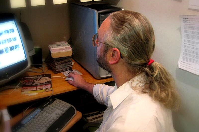 A man sits as a computer working.