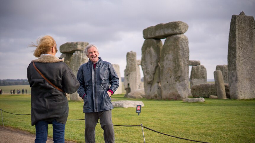 A tourist poses for a photo at Stonehenge.