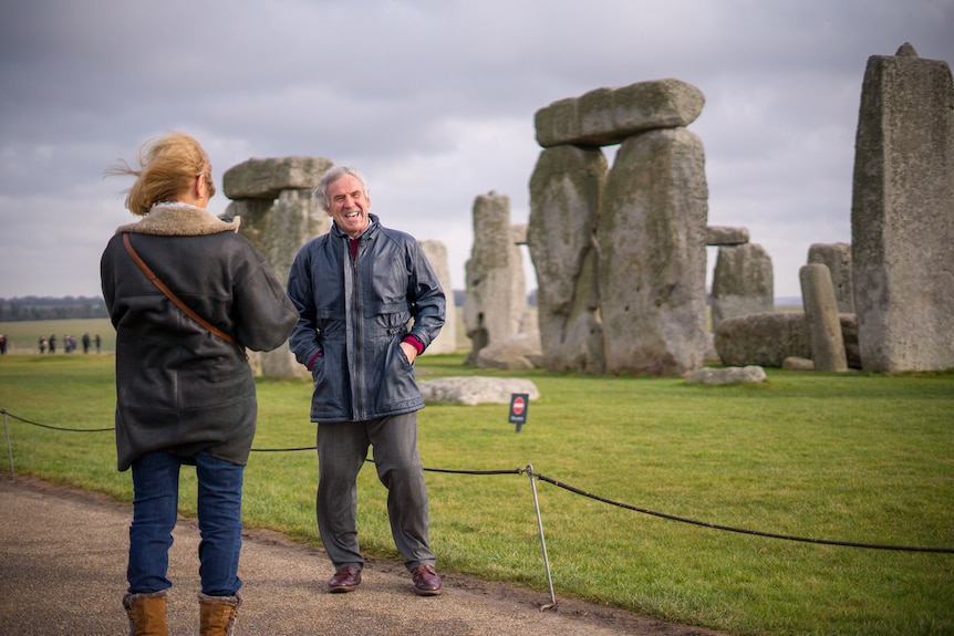 A tourist poses for a photo at Stonehenge.