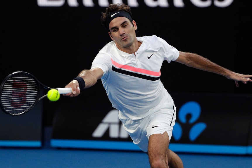 Roger Federer stretches for a forehand against Aljaz Bedene in their Australian Open first-round match.