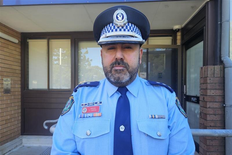 A bearded man in blue police uniform.