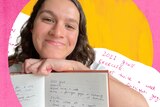 Rachel Rasker, who was wavy brown hair, smiles with a notebook with handwritten '2022 goals' in it.