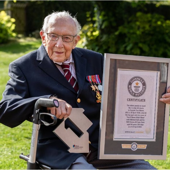 Captain Tom Moore holds his number one trophy and Guinness World Record plaque.