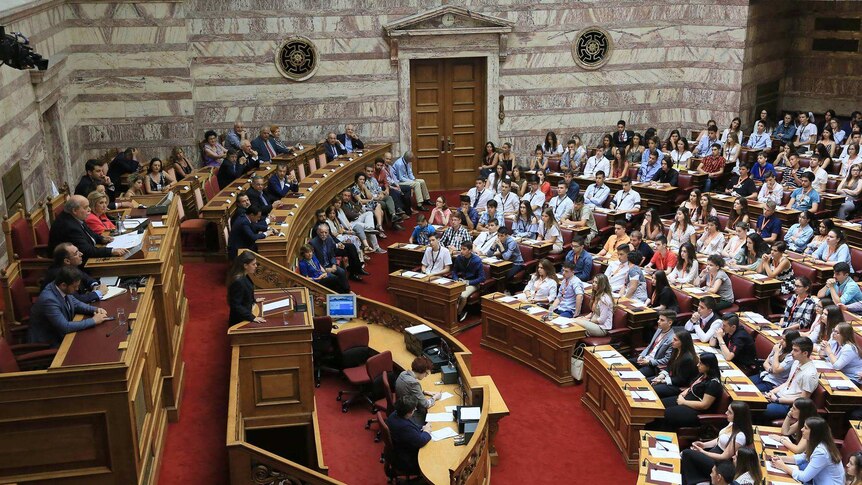 Ministers sit at Parliament benches, while the students fill the rows of members' seats