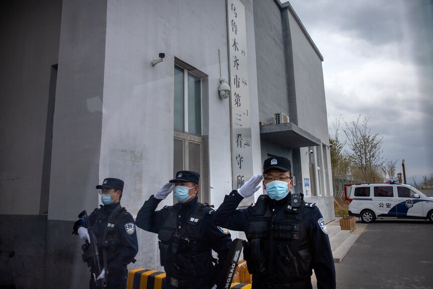 Police officers salute at the outer entrance of the detention centre