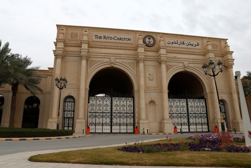 A grand, off-white entrance to a hotel, with columns and two gates, reading 'the Ritz-Carlton'