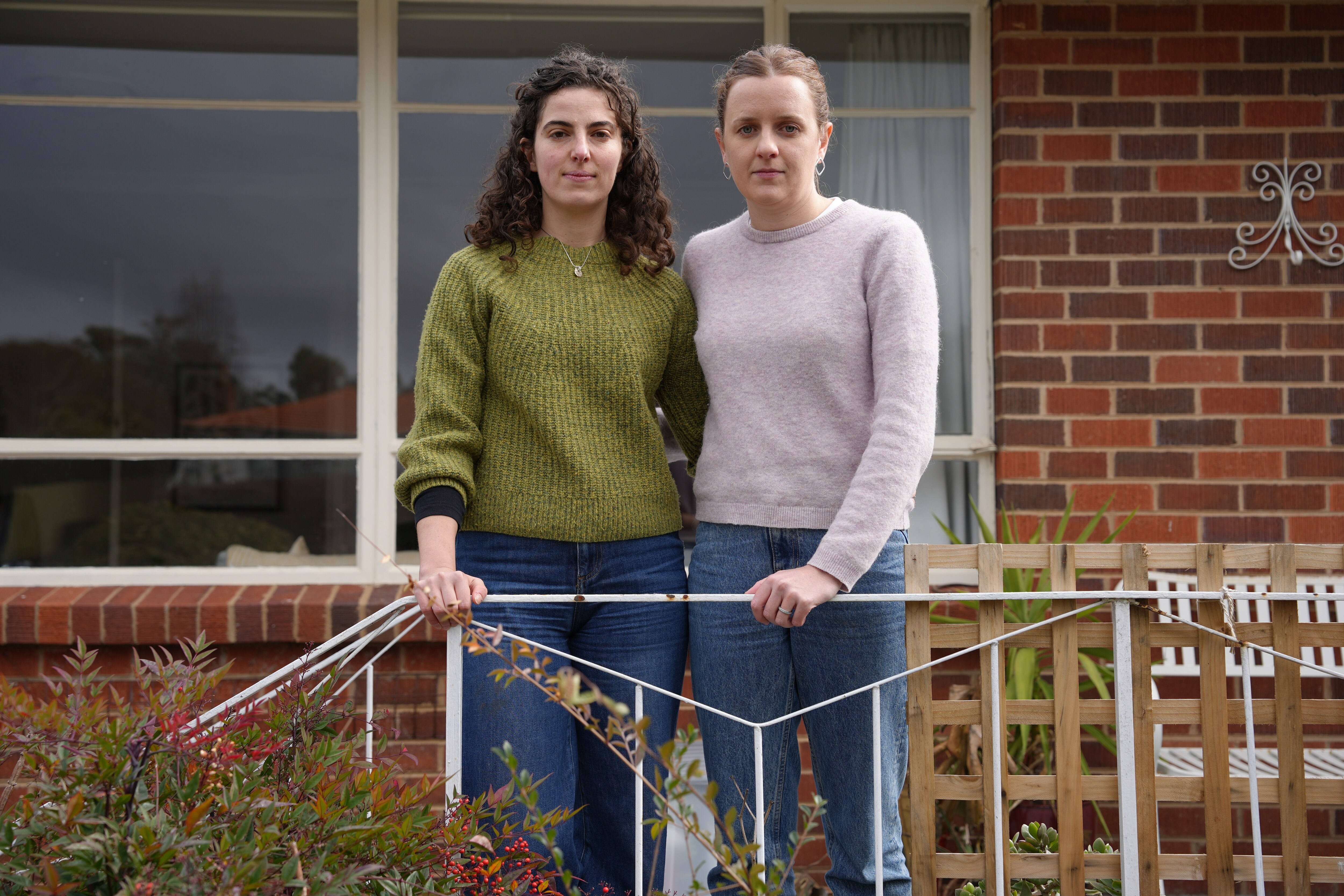 Two women standing on their front porch