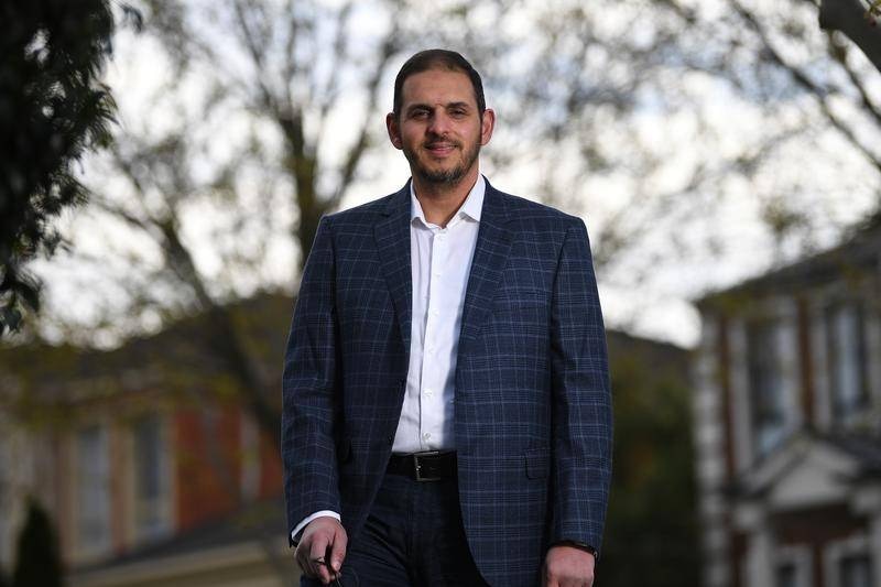 A man poses outside for a professional portrait