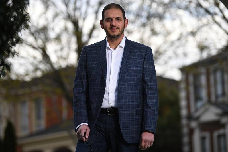 a man in suit standing in front of buildings