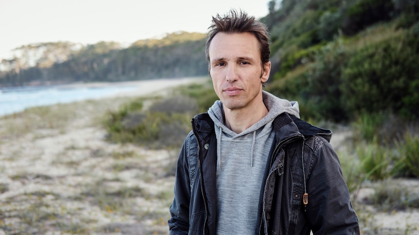 A man stands on a beach.