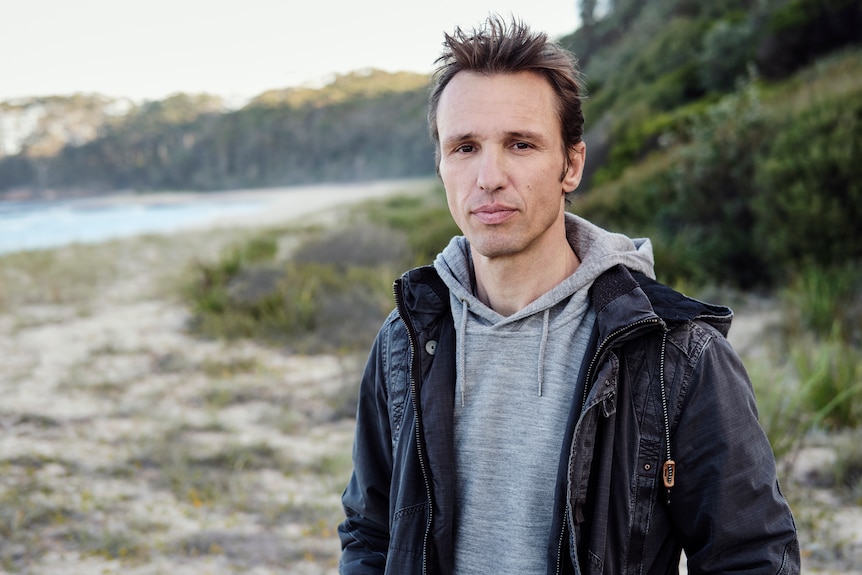 A man stands on a beach.