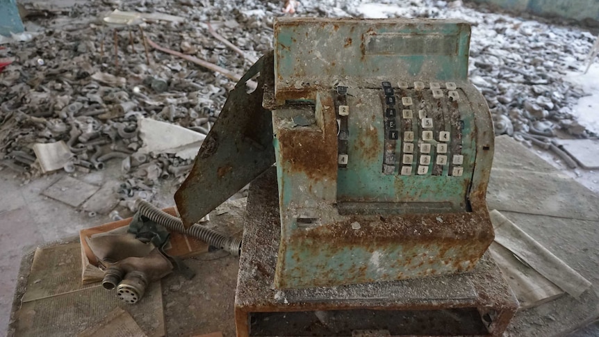 Cash register with gas masks on floor in background of cafeteria of school in Pripyat