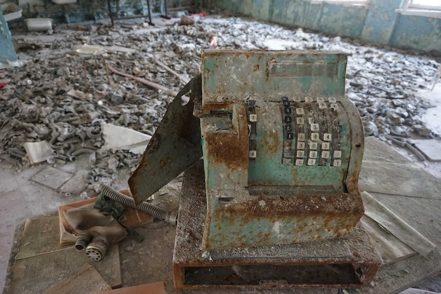 Cash register with gas masks on floor in background of cafeteria of school in Pripyat