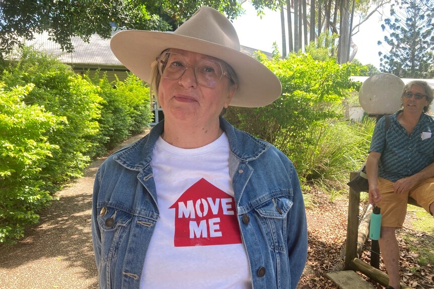 A woman wearing glasses, a heat, and a tee short saying "Move Me".
