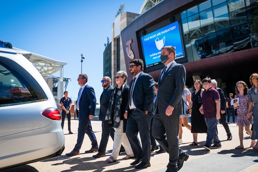 Rod Marsh's family walk behind the hearse carrying his casket