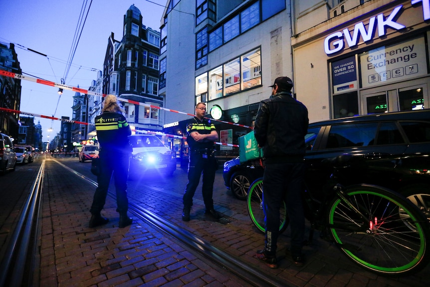 Police standing guard in front of the area where Dutch celebrity crime reporter Peter R. de Vries was shot. 