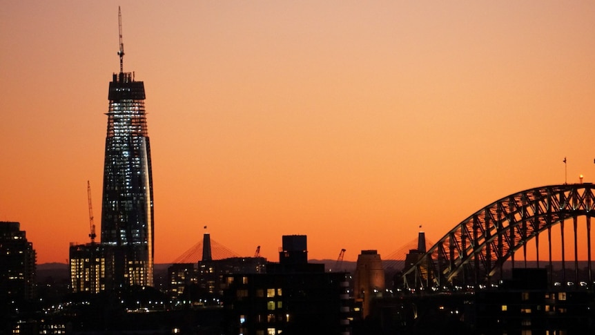 A picture of a large, incomplete building at sunset.