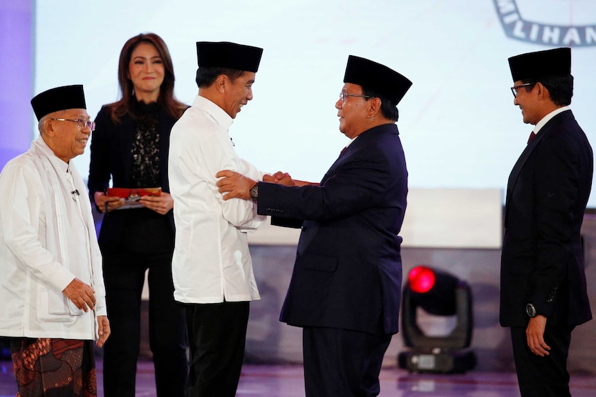 Indonesia's presidential candidates shake hands on stage.