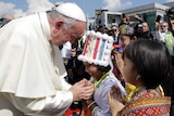 Pope Francis greets two young children in Yangon.