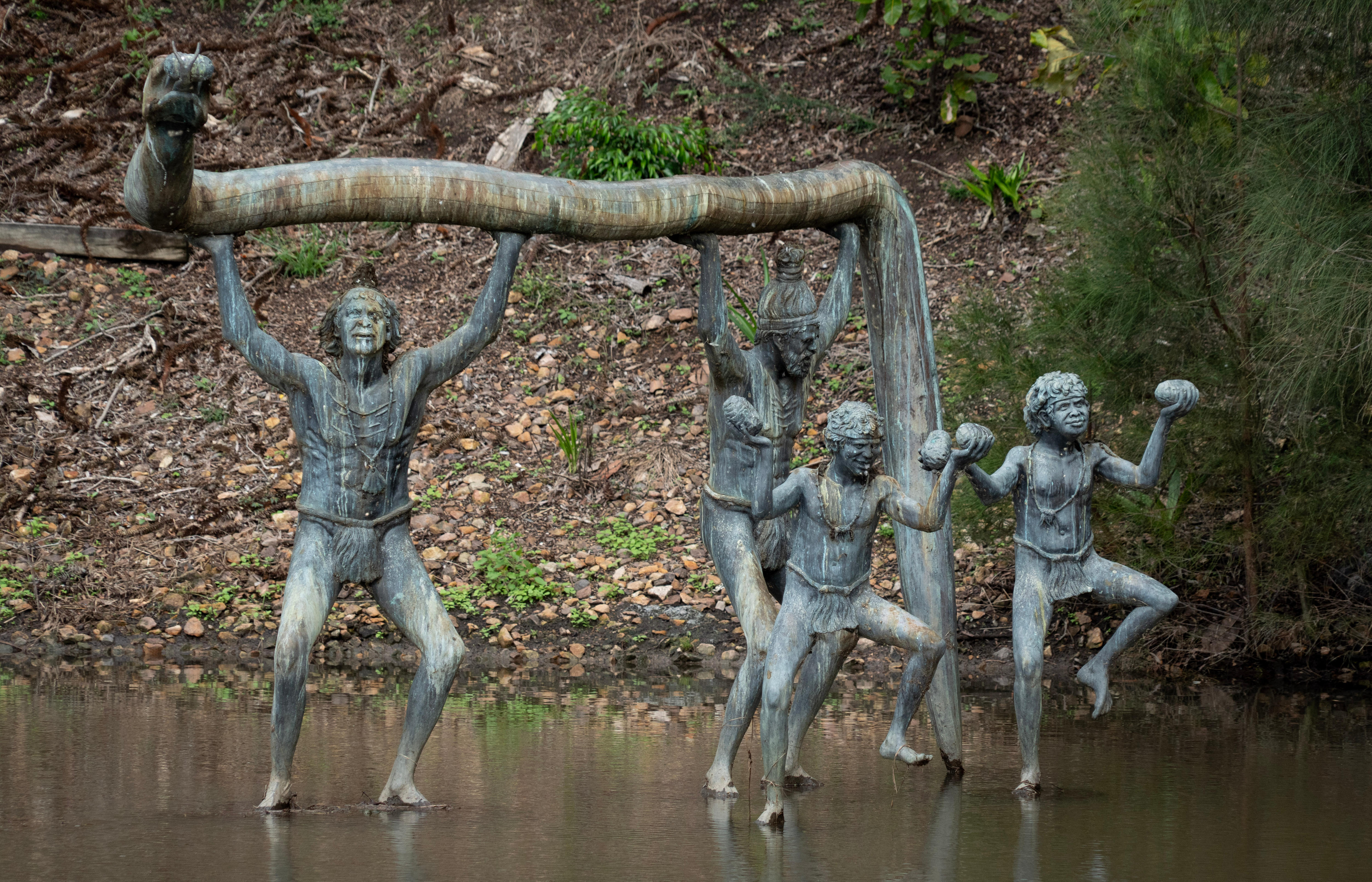 Statue depicting multiple people in a creek.