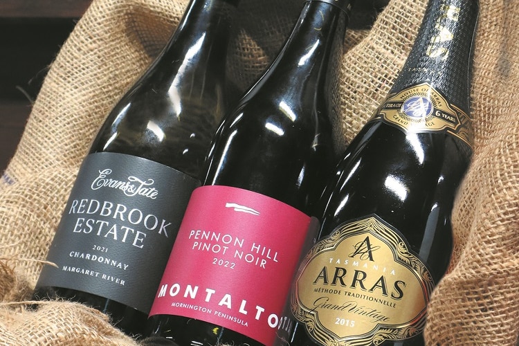 Three award-winning bottles of wine nestled together on a hessian sack.