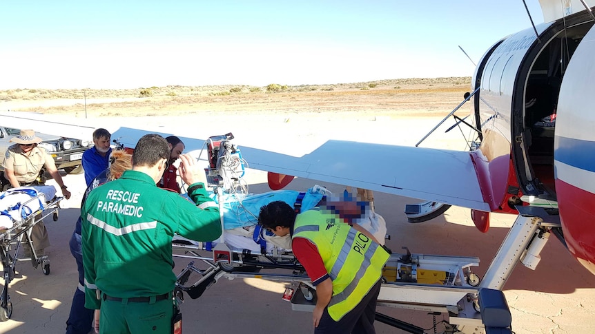 Medical staff load a patient onto a Royal Flying Doctor Service plane.