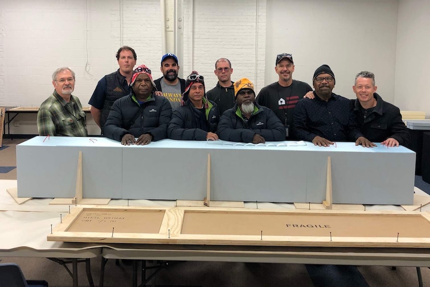 Traditional owners standing with returned artefacts