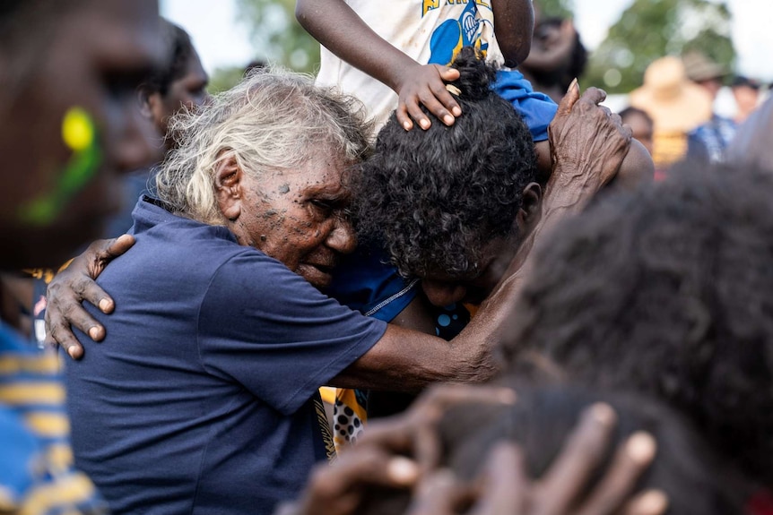 Two family members embrace after the Tiwi football grand final.