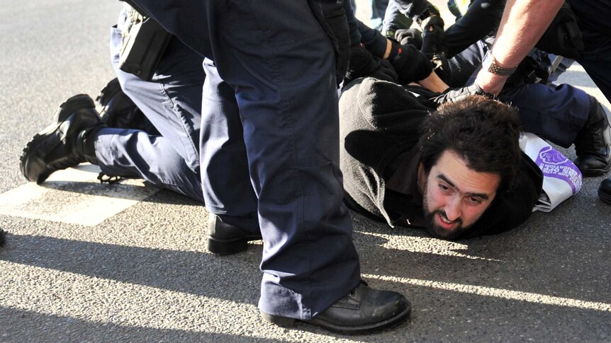 Police detain a protester at Melbourne University a speech by Foreign Minister Julie Bishop