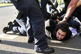 Police detain a protester at Melbourne University a speech by Foreign Minister Julie Bishop