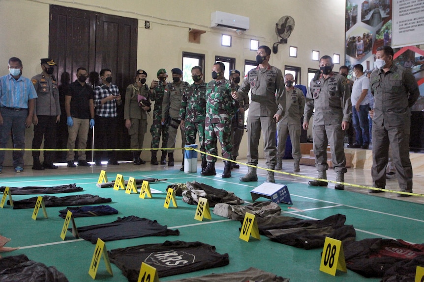 Security forces stand by pieces of evidence placed on the floor 