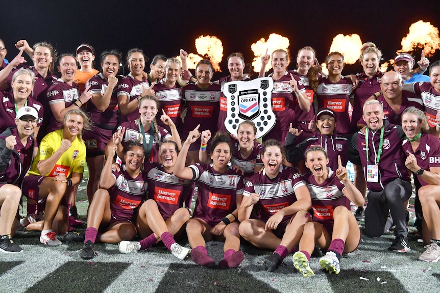 Las jugadoras de Queensland celebran con el escudo de las ganadoras tras vencer a NSW en el Women's State of Origin.