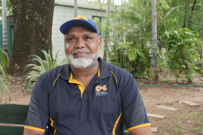 A middle-aged man wearing a Northern Land Council shirt, smiling