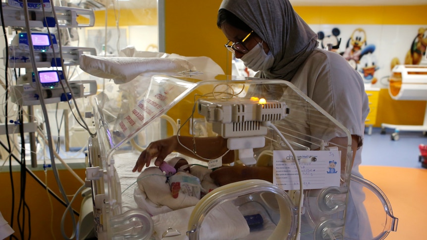 Nurse watches over one of the nine babies 