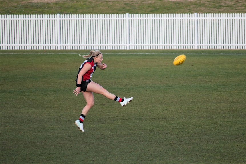 An Ainslie Football Club player kicks the ball during a match.