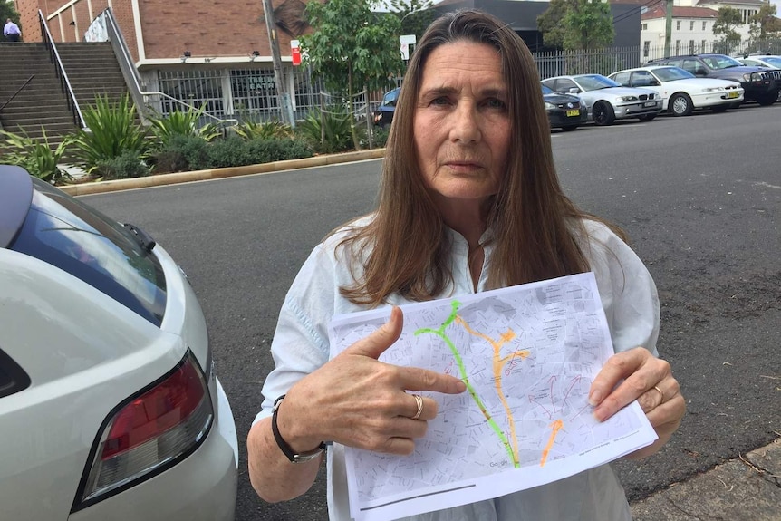 A woman holding a map outside on a street.