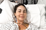 British reality TV star Louise Thompson lying in a hospital bed with a hospital gown on