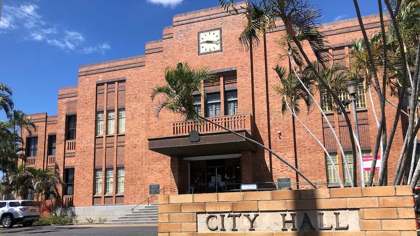 A large red brick building with a sign out the front that reads City Hall