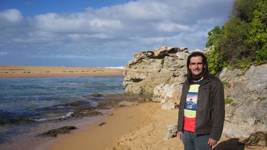 Brett Clarke standing on the sand next to the mouth of the Hopkins River