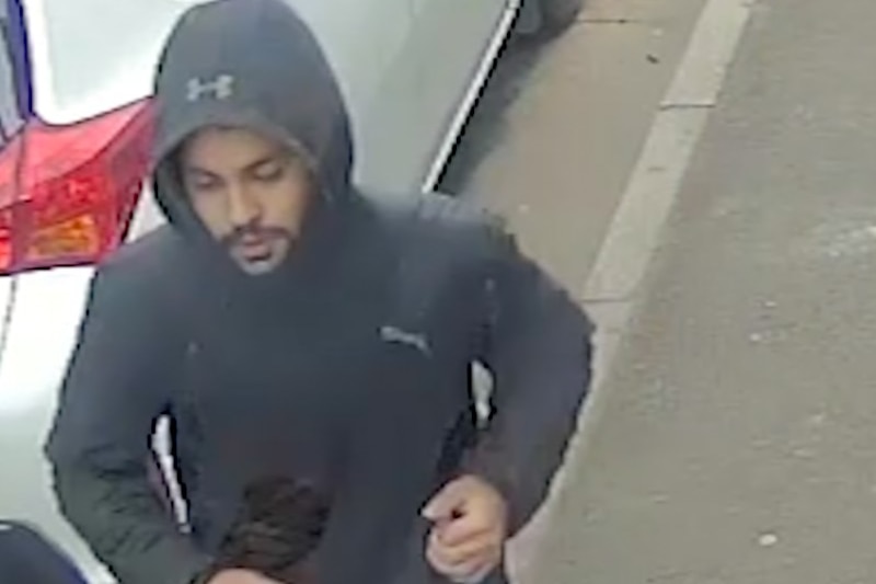 A man in a black hooded top, caught on CCTV footage.