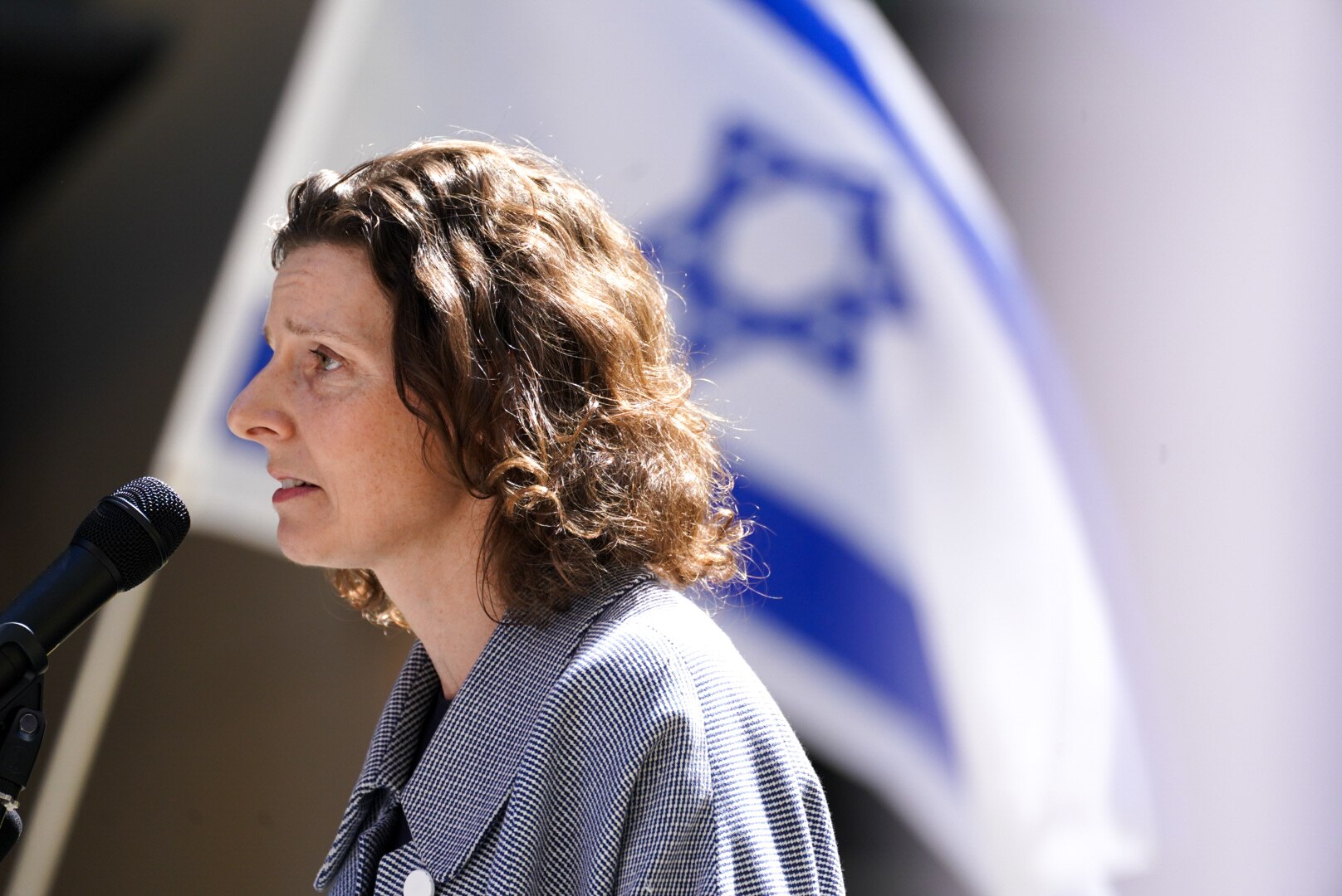 Allegra Spender with a coat and brown hair speaks at pro-Israel rally